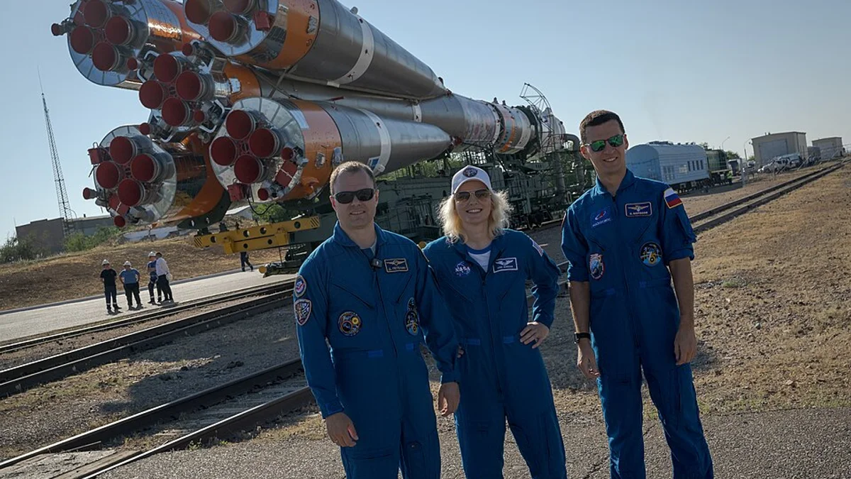 NASA astronotu Deniz Burnham Baykonur Uzay Üssünde Soyuz roketi önünde kozmonotlar Dmitri Petelin ve Konstantin Borisov ile